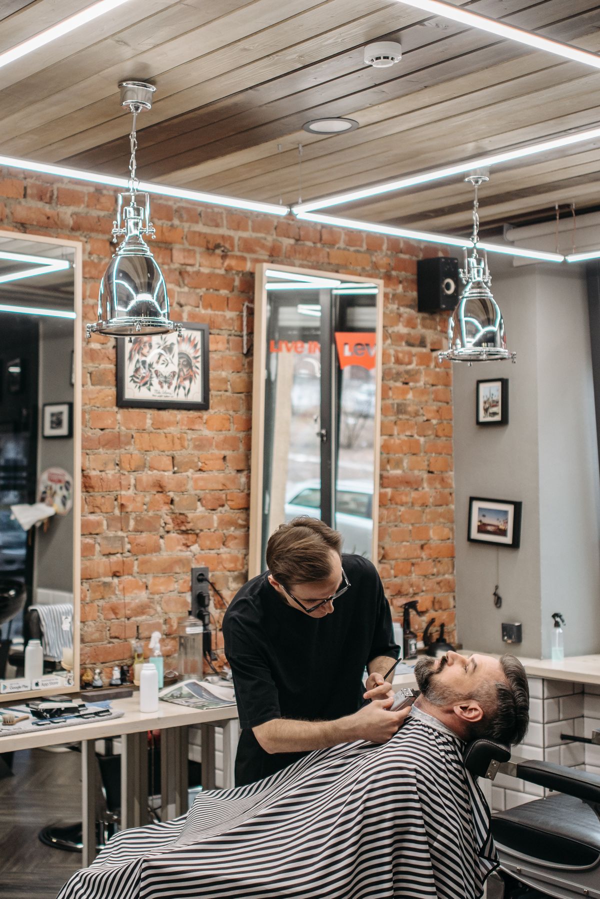 Stockfoto: Barber trimmt den Bart eines zurückgelehnten Kunden